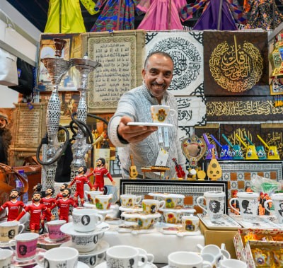  Exhibitor holding up a product, a teacup